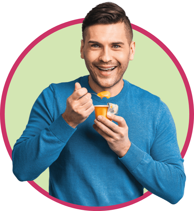 man smiling and holding the spoon in one hand and the orange jar in the other